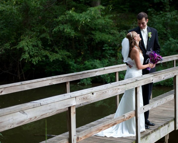 bride and groom standing on bridge